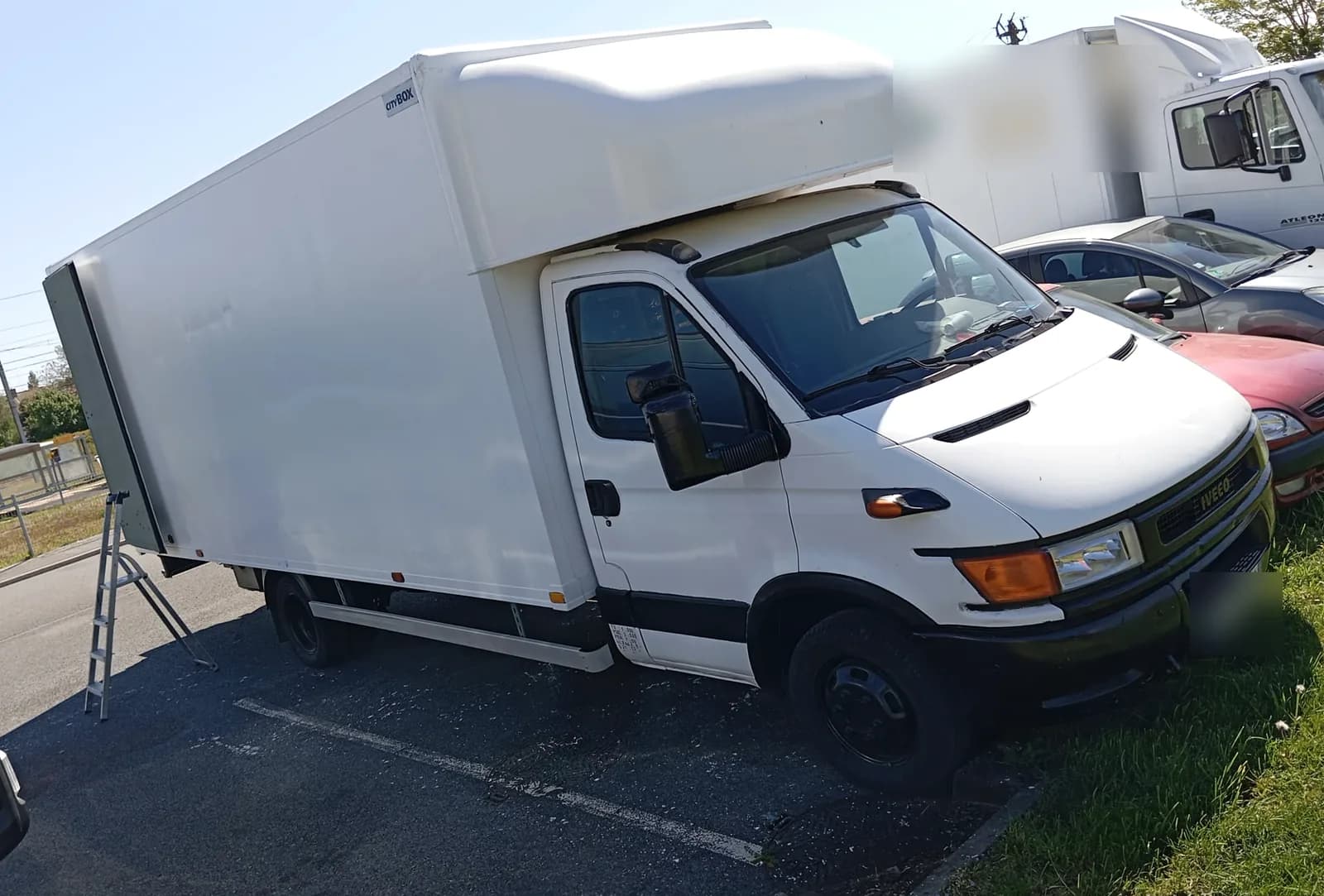 Camion de déménagement à caisse blanche, vu de trois quarts