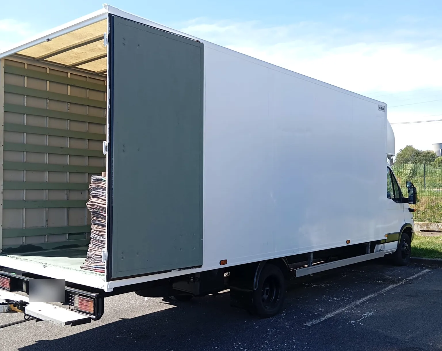 Camion de déménagement ouvert sur le côté, couvertures de protection prêtes au chargement